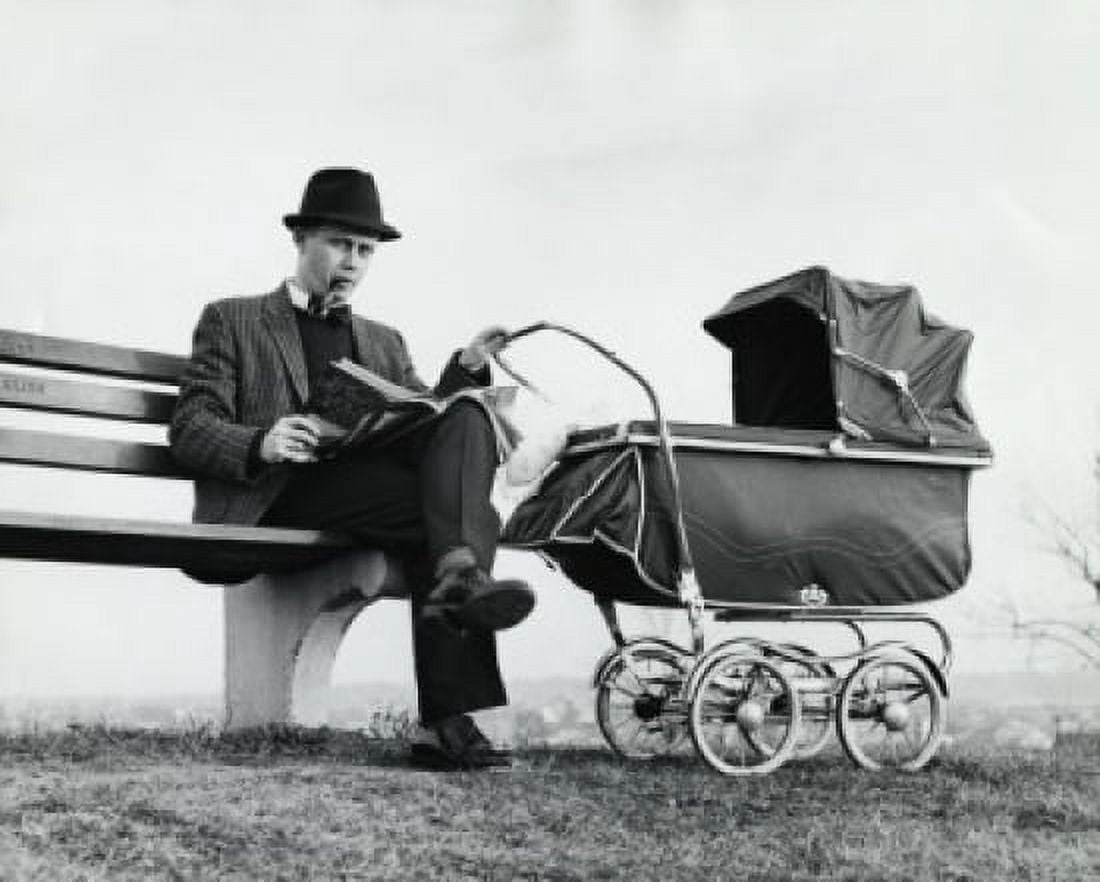 Father sitting on a bench holding a baby carriage Canvas Art - (18 x 24)