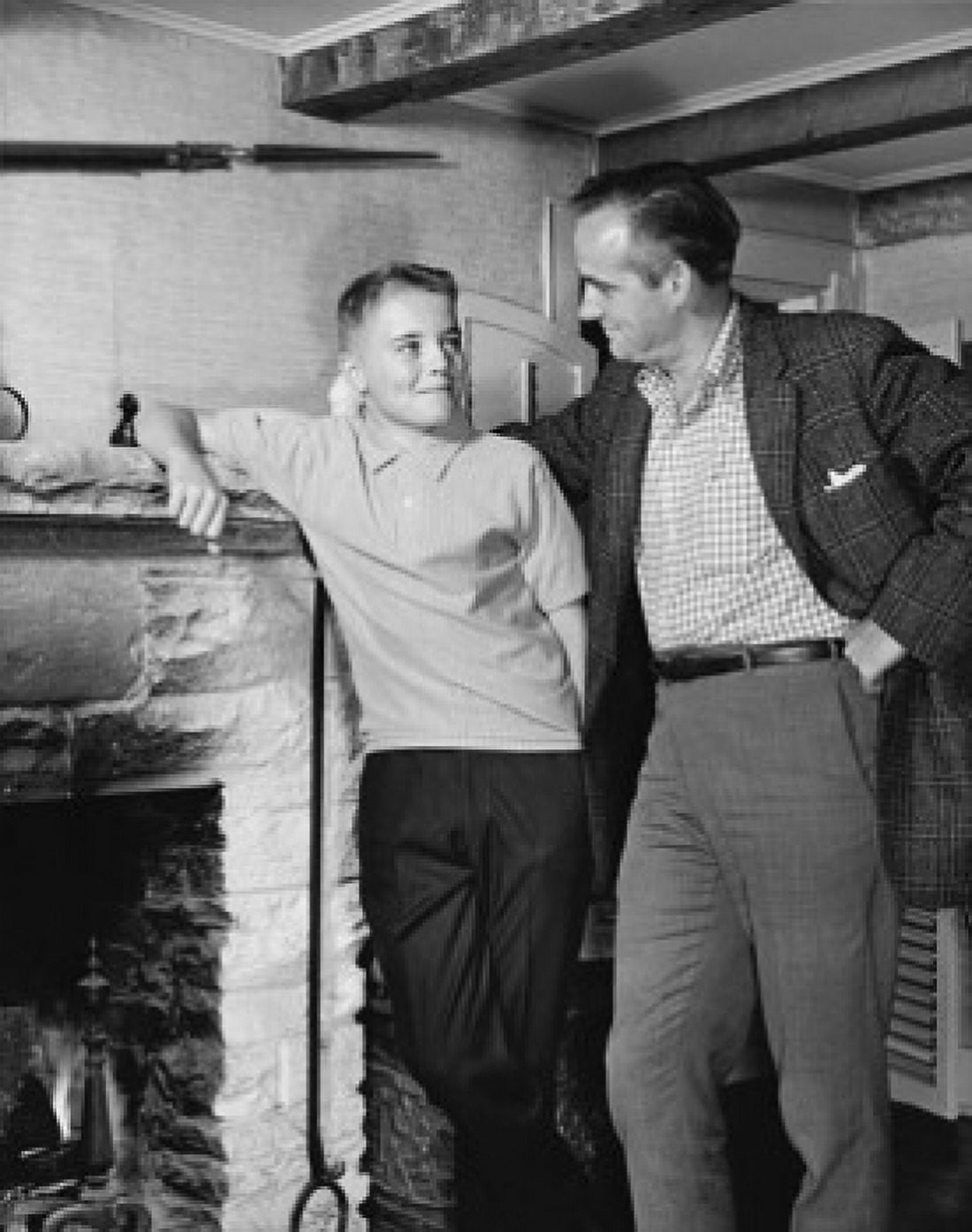 Father standing with his son near a fireplace Canvas Art - (18 x 24)