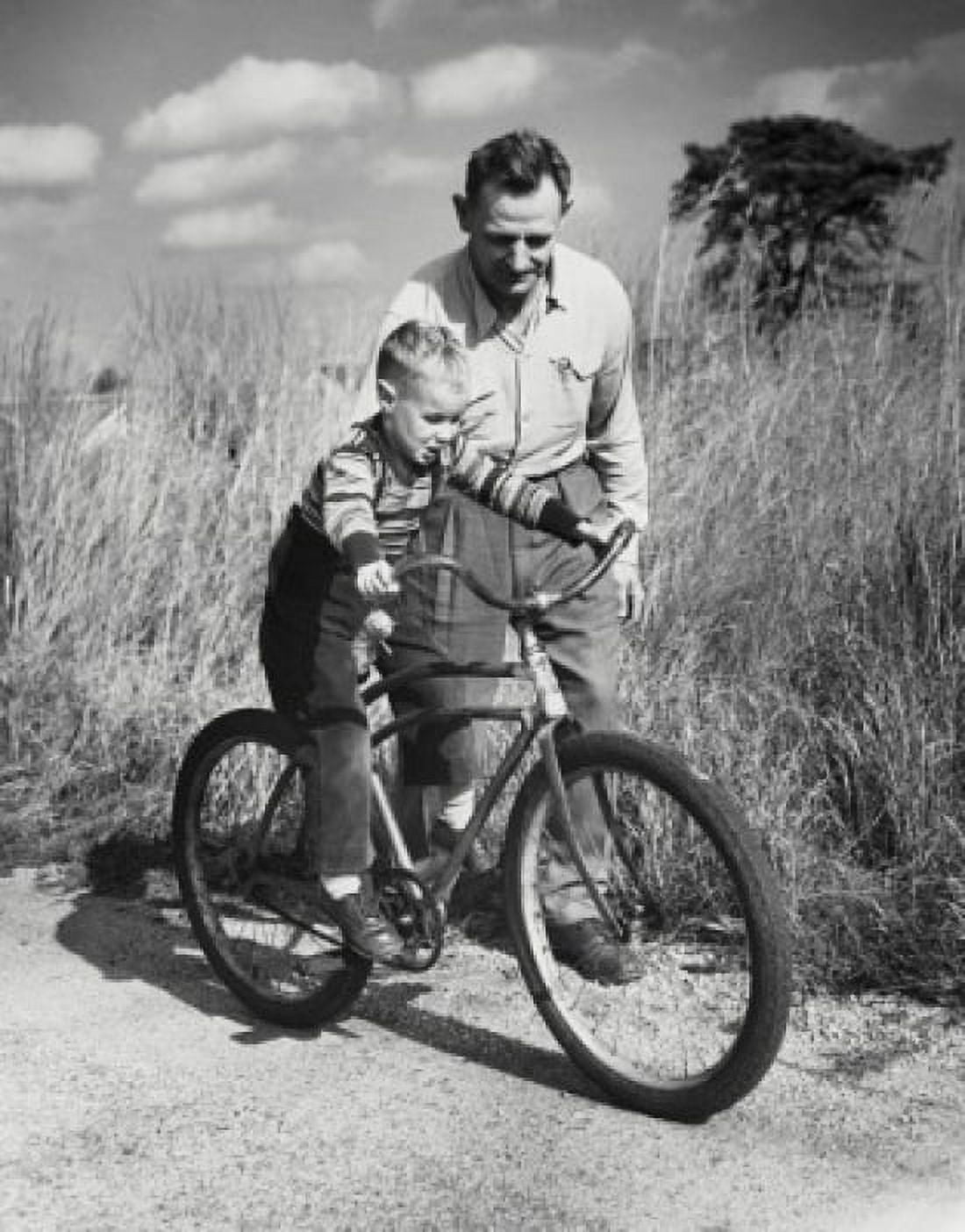 Father teaching his son to ride a bicycle Canvas Art - (24 x 36)