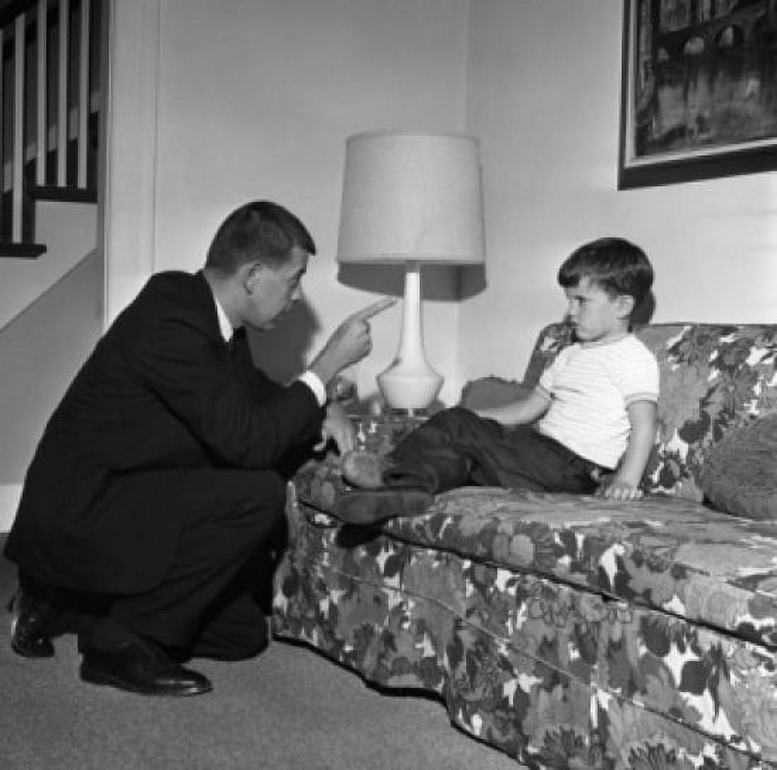 Father telling off son on living room sofa Canvas Art - (24 x 36)