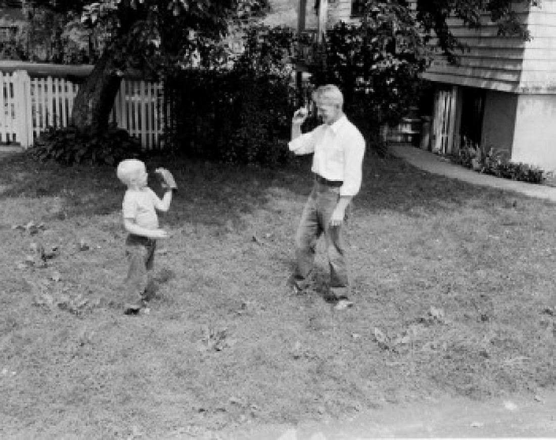 Father throwing ball to son in garden Canvas Art - (24 x 36)
