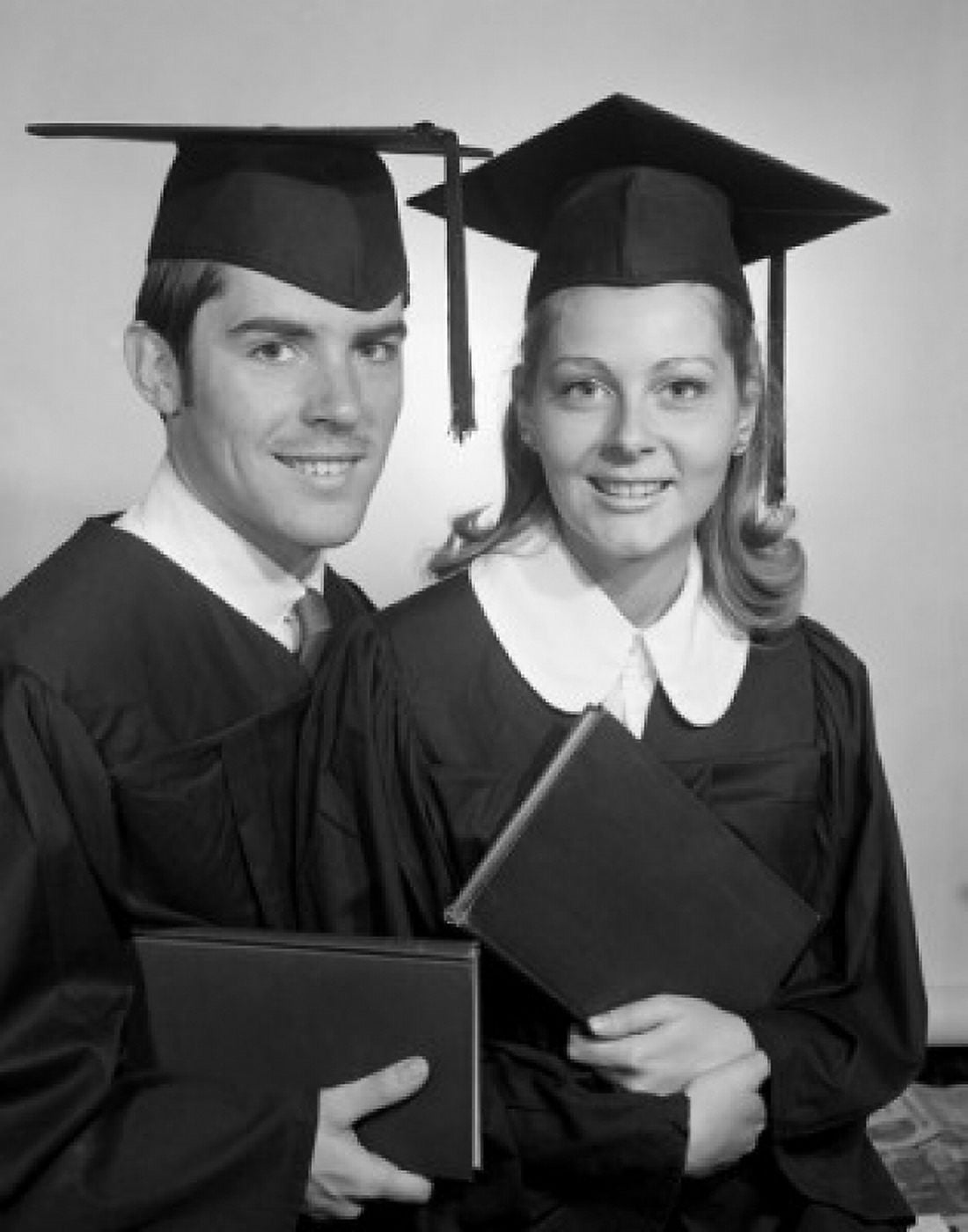 Female and male students wearing graduation gown holding diploma Canvas Art - (18 x 24)