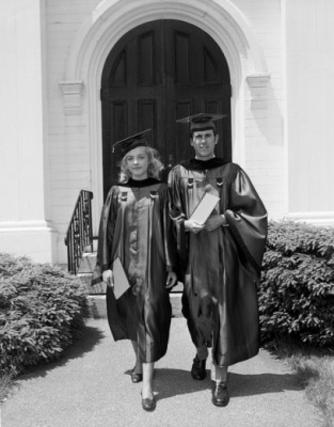 Female and male students wearing graduation gown holding diploma Canvas Art - (24 x 36)