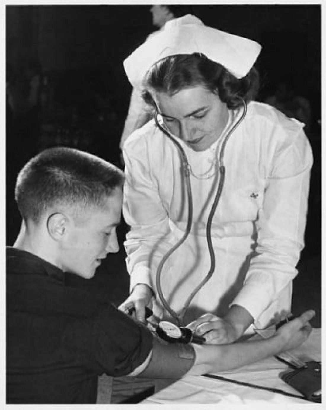 Female nurse checking a young mans blood pressure Canvas Art - (24 x 36)