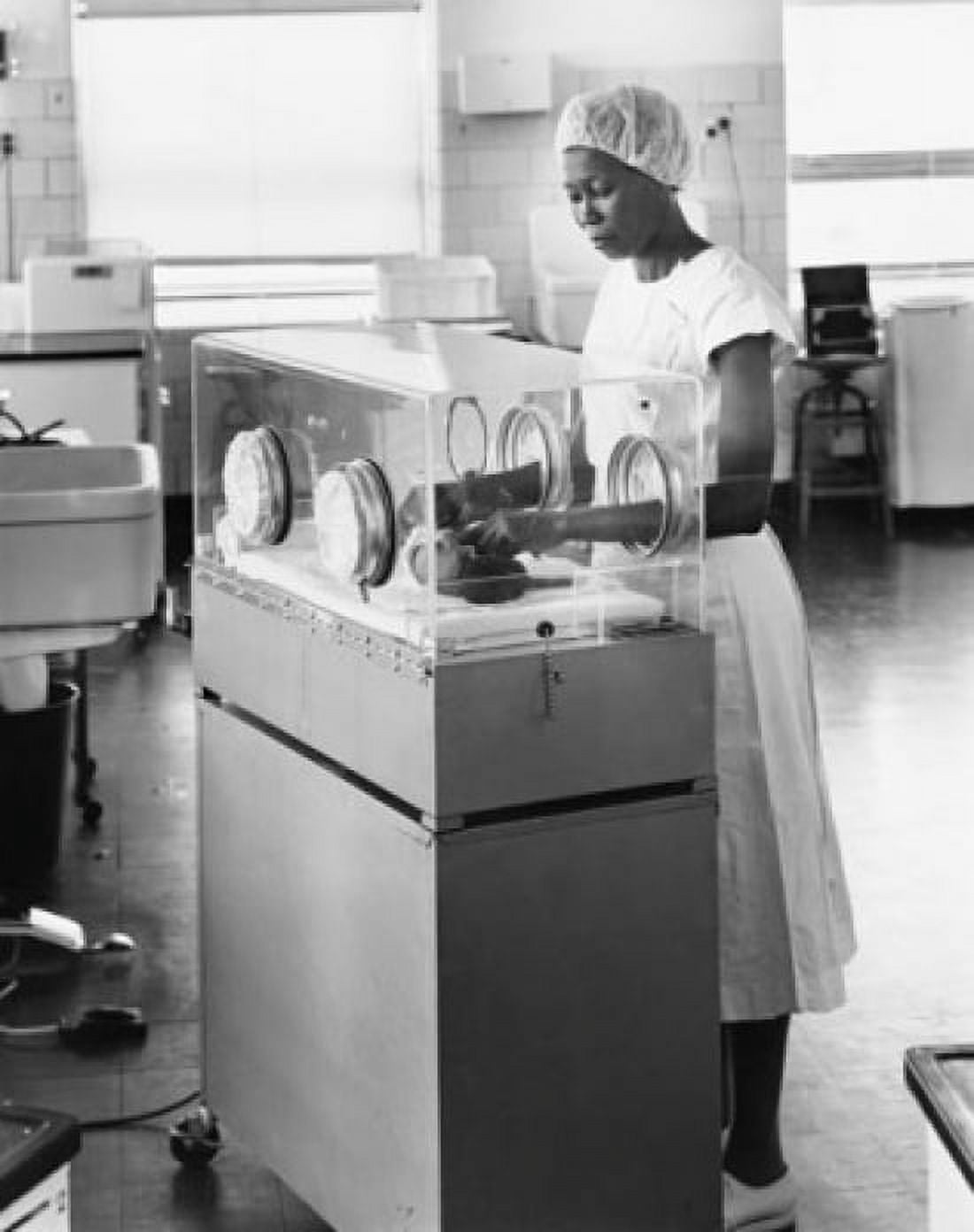 Female nurse examining a newborn baby in an incubator Canvas Art - (24 x 36)