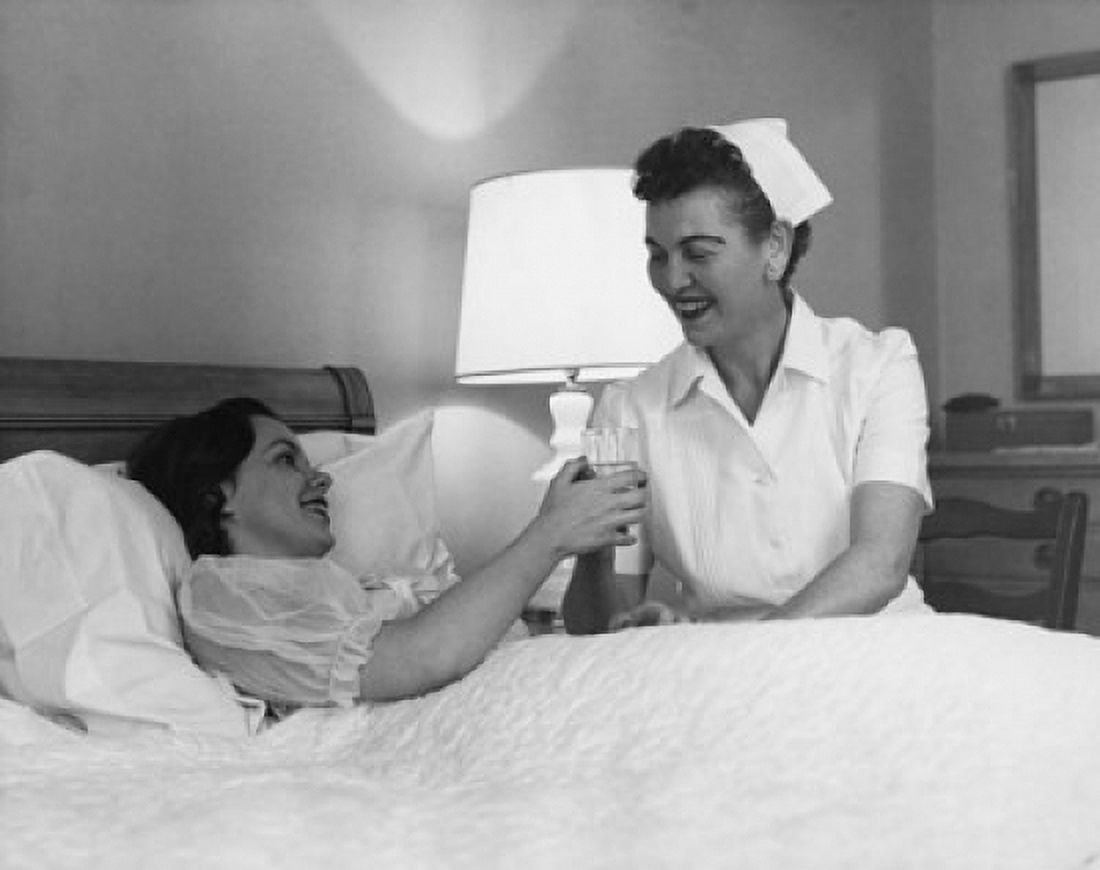 Female nurse giving a glass of water to a young woman Canvas Art - (24 x 36)