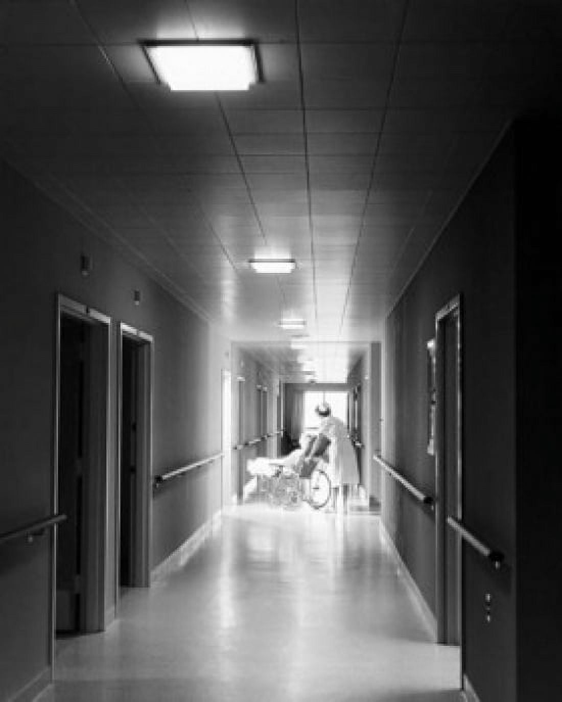 Female nurse pushing a patient on a wheelchair in a corridor Canvas Art - (18 x 24)
