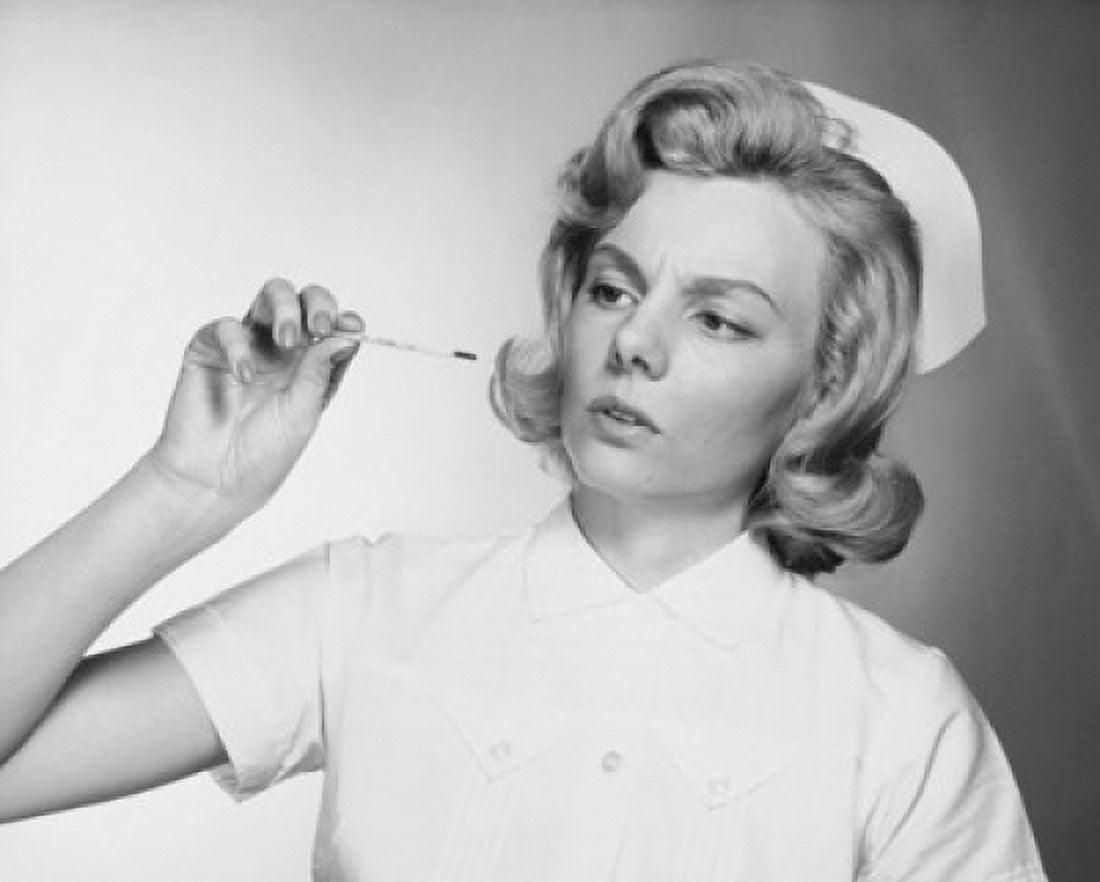 Female nurse reading a thermometer Canvas Art - (18 x 24)