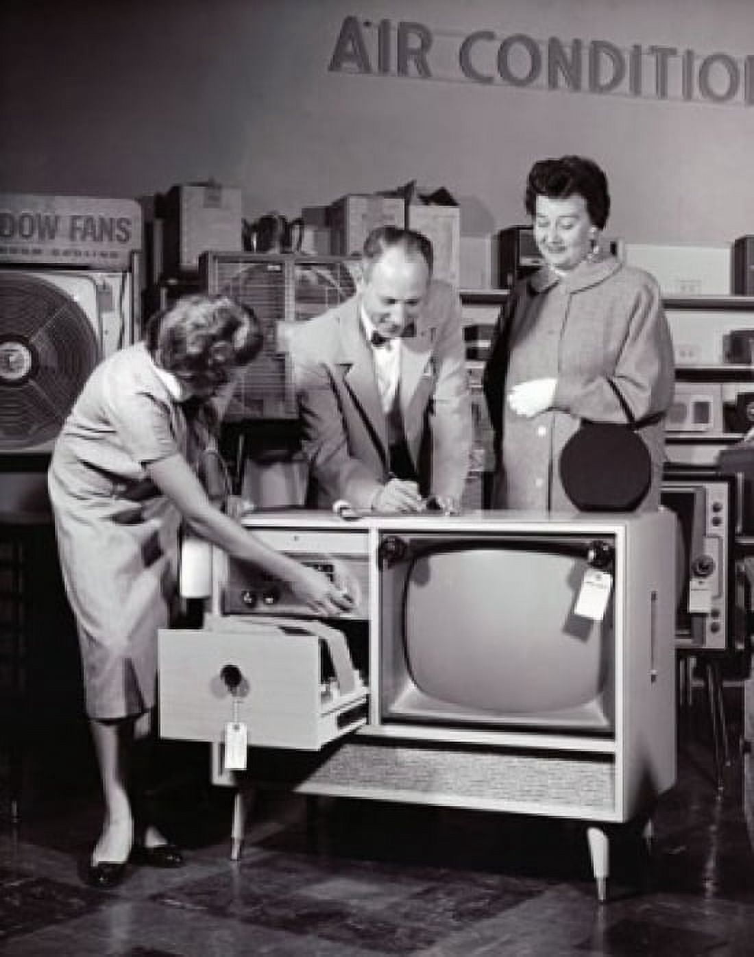 Female sales clerk showing a television set to a customer in an electronic shop Canvas Art - (18 x 24)