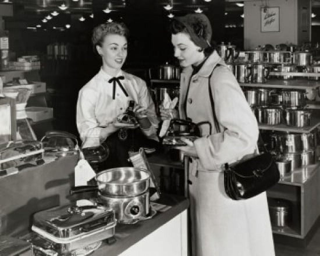 Female sales clerk showing irons to a customer in a store Canvas Art - (18 x 24)