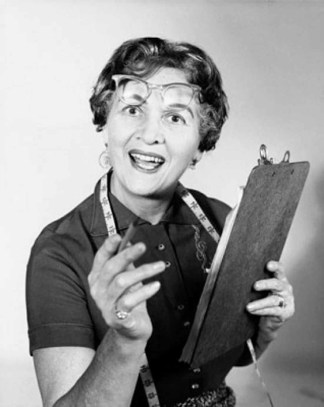 Female tailor holding a clipboard and pointing forward Canvas Art - (18 x 24)