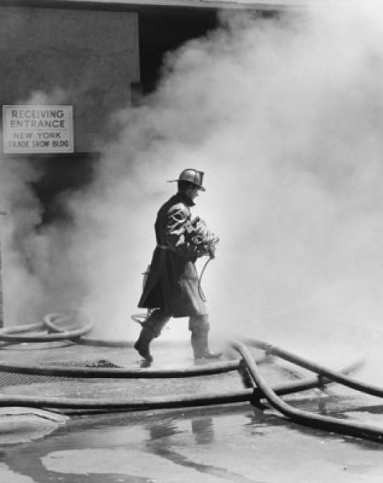 Firefighter walking in front of smoke Canvas Art - (18 x 24)