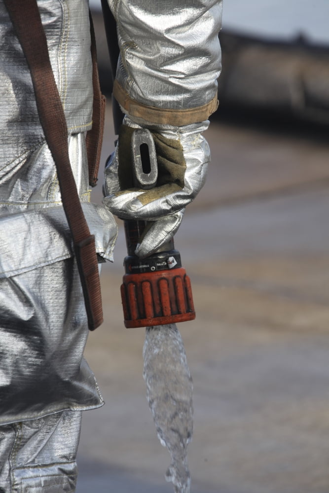 Firefighting Marine tests his hand line nozzle to check the water flow Canvas Art - Stocktrek Images (23 x 35)