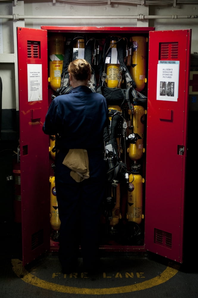 Fireman stows a self-contained breathing apparatus in a locker Canvas Art - Stocktrek Images (23 x 35)