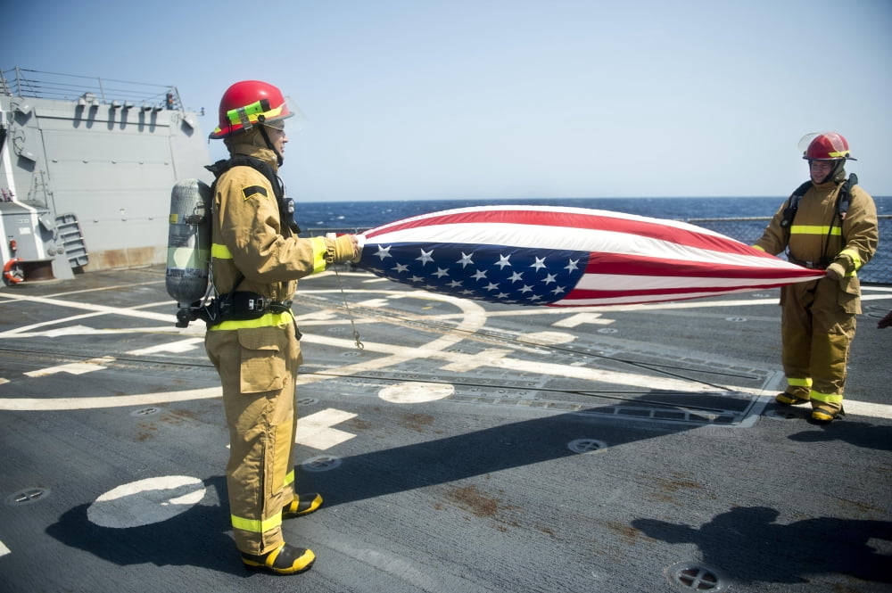 Firemen fold the American flag aboard USS William P Lawrence Canvas Art - Stocktrek Images (34 x 23)