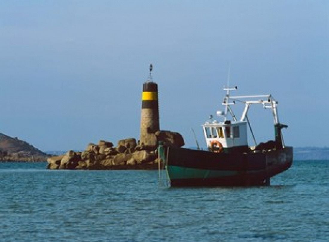 Fishing trawler in front of a lighthouse at Port Saint-Sauveur Ile Grande Cotes-dArmor Brittany France Canvas Art - Panoramic Images (36 x 27)