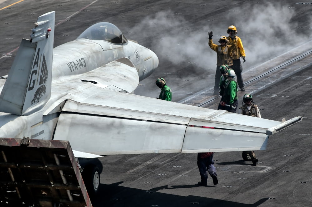 Flight deck crew position an FA-18E Super Hornet into launch position aboard USS Eisenhower Canvas Art - Giovanni CollaStocktrek Images (35 x 24)