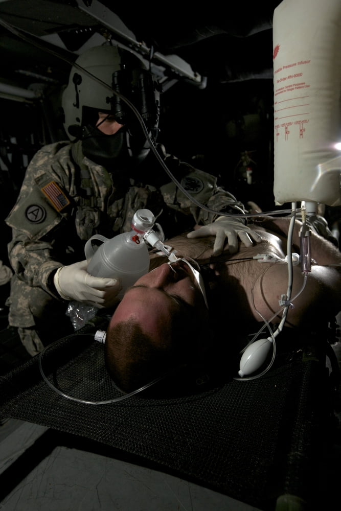 Flight medic looks after a mock patient in a UH-60 Black Hawk helicopter Canvas Art - Terry MooreStocktrek Images (23 x 35)
