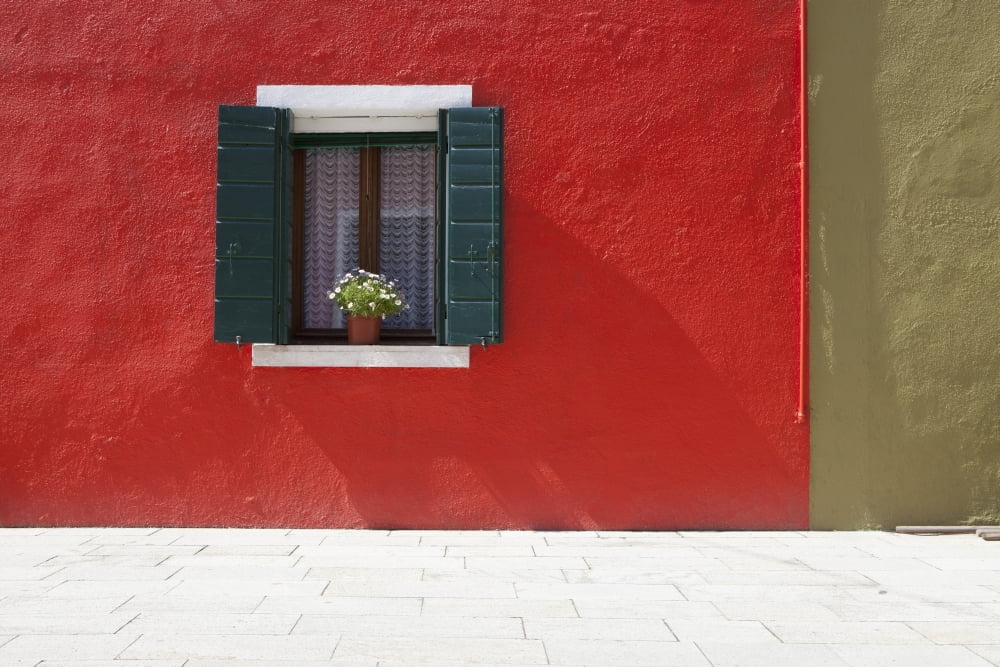 A Flower Pot Sits In A Window With Shutters Open In Building Painted Bright Red Burano Venezia Italy Canvas Art - David DuChemin Design Pics (38 x 24)