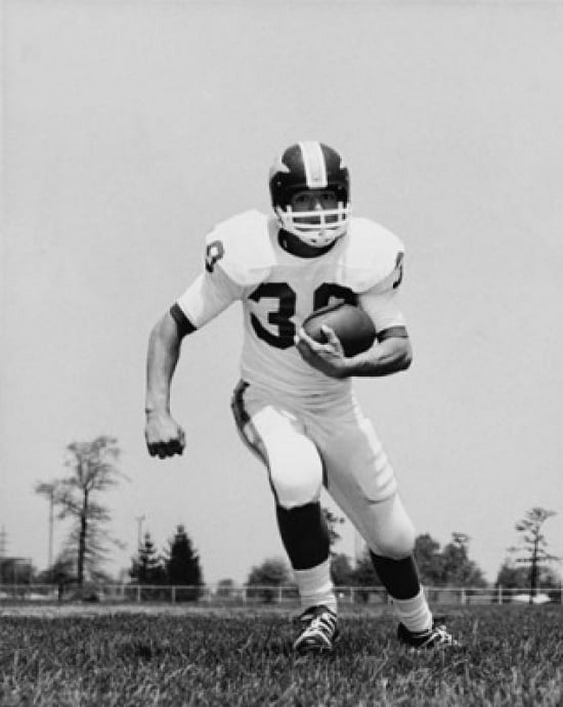 Football player running with a football on a football field Canvas Art - (18 x 24)