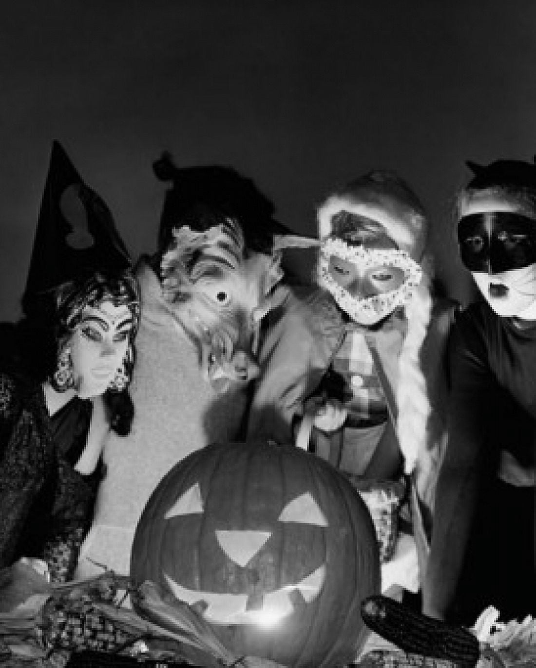 Four children wearing Halloween costumes looking at an illuminated jack o lantern Canvas Art - (18 x 24)