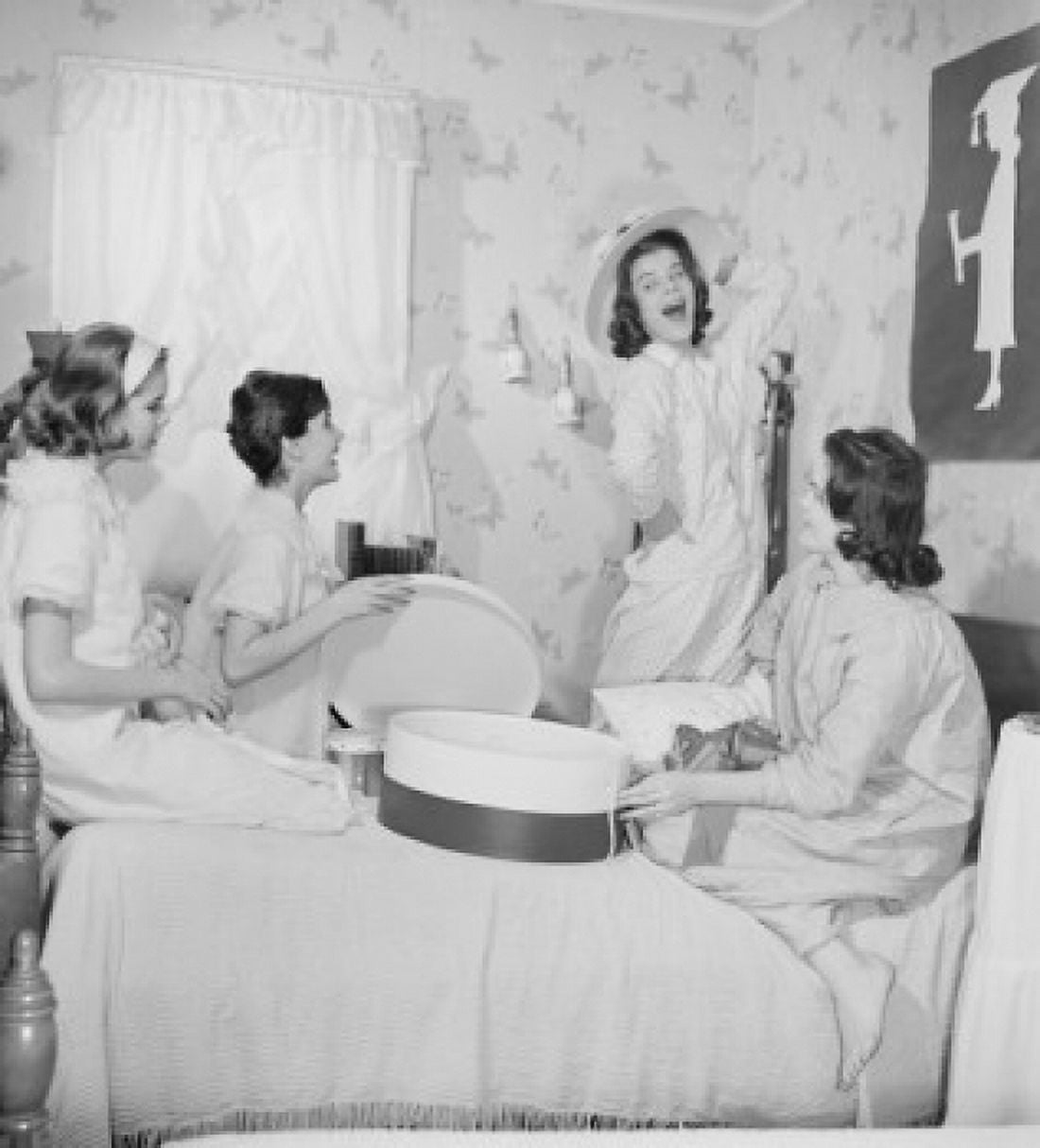 Four young women fitting hats in bedroom Canvas Art - (18 x 24)