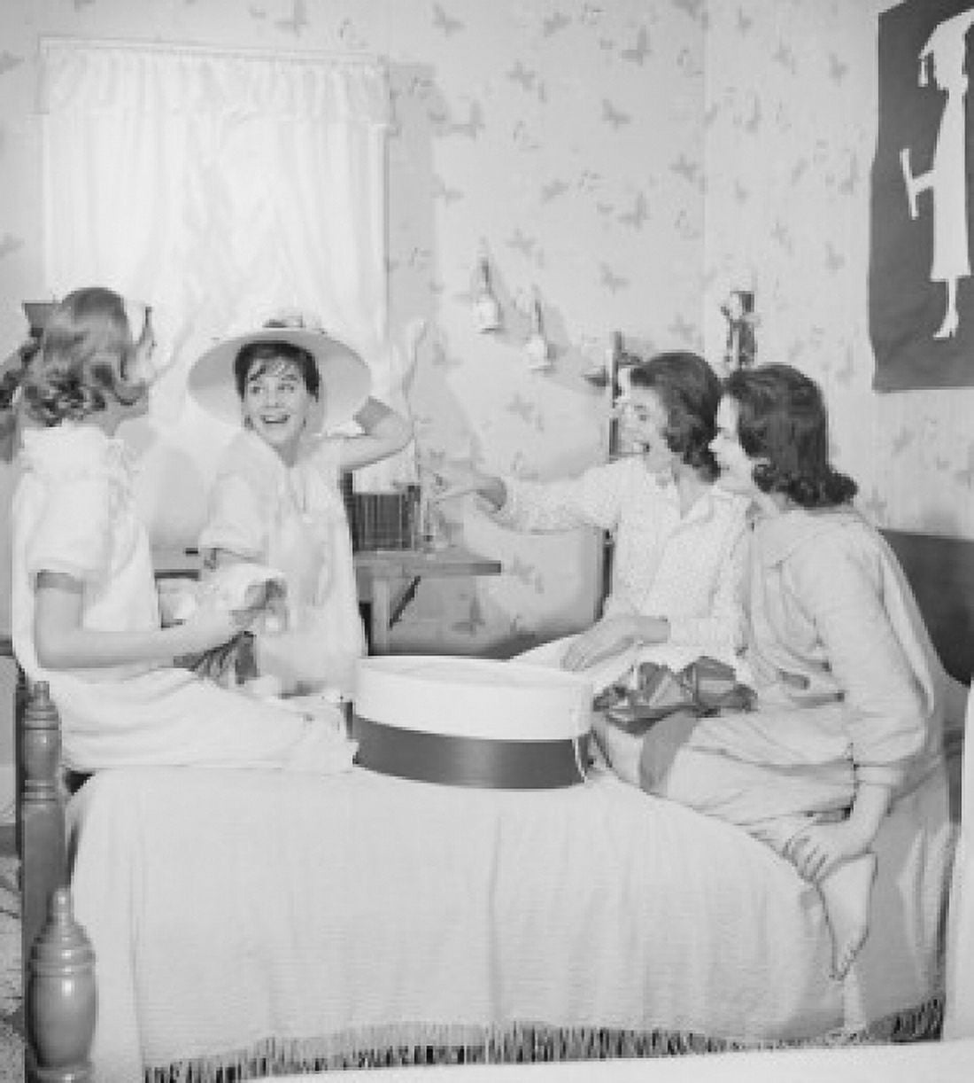 Four young women fitting hats in bedroom Canvas Art - (24 x 36)