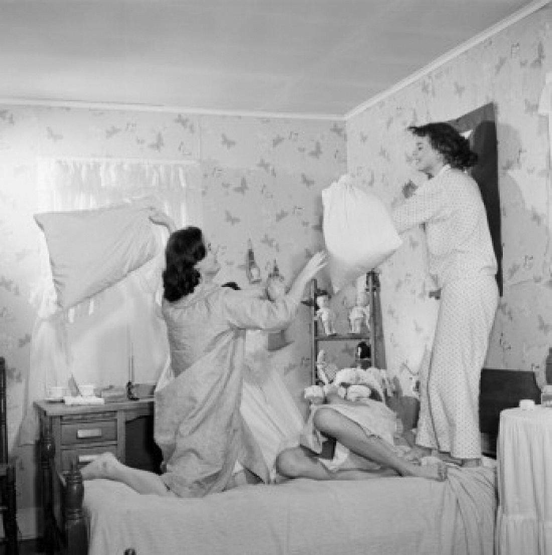 Four young women having pillow fight in bedroom Canvas Art -  (18 x 24)