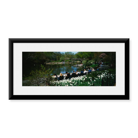 Framed Art Print, Group of people sitting on benches near a pond by Panoramic Images, 25-7/8" x 9-7/8"