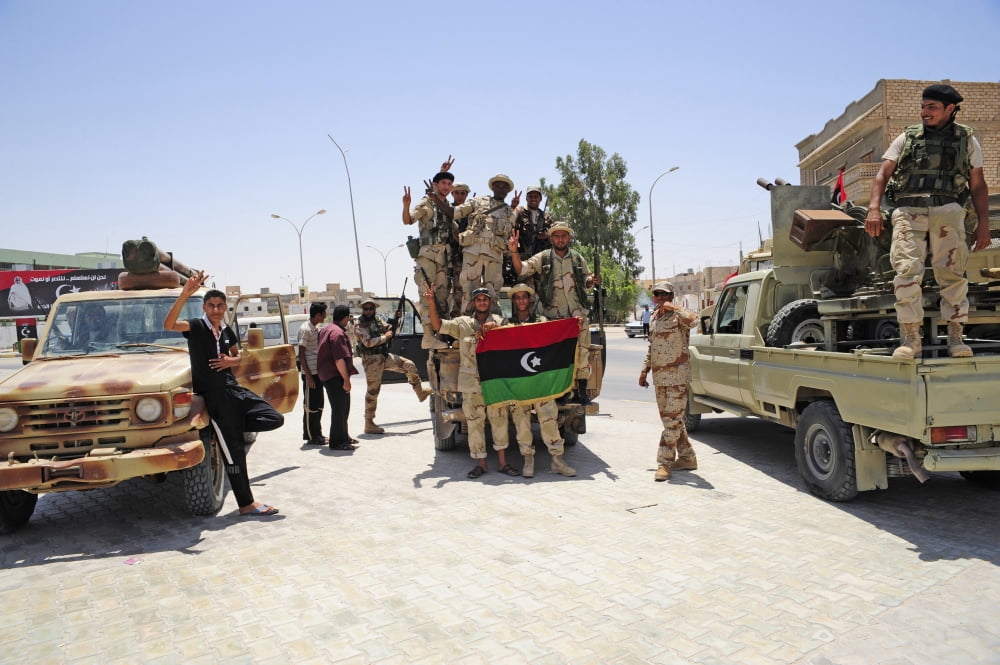 Free Libyan Army troops pose with the Flag of the National Transitional Council Canvas Art - Andrew ChittockStocktrek Images (35 x 23)
