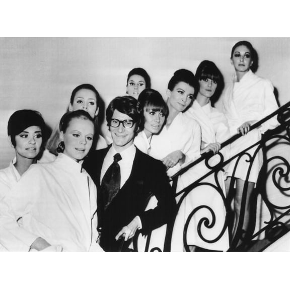 French Fashion Designer Yves Saint Laurent With Models Showing His 1967 Spring Summer Collection. The Models Are Made-Up And In Their Smocks Before The Collection Showing. Saint Laurent Touched Made