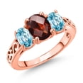 thumbnail image 1 of Gem Stone King 18K Rose Gold Plated Silver Red Garnet and Blue Zircon Filigree Style 3 Stone Ring for Women (2.83 Cttw, Oval 8X6MM and 6X4MM) (Size 7), 1 of 6