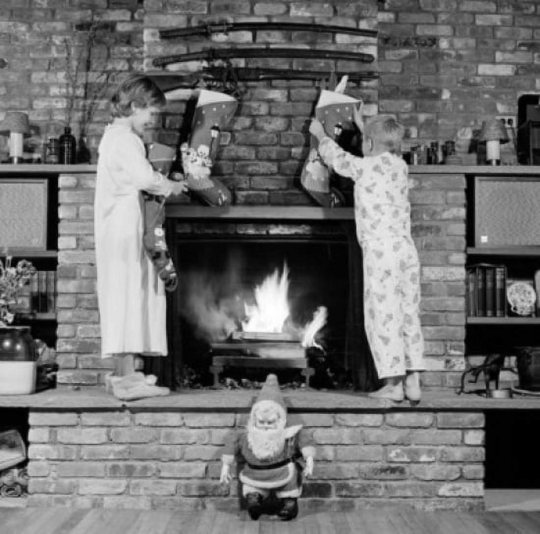 Girl and boy decorating fireplace with christmas stockings Canvas Art - (18 x 24)