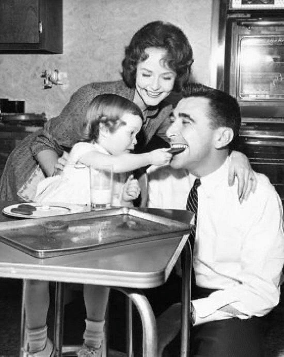 Girl feeding a cookie to her father with her mother looking at them Canvas Art - (24 x 36)