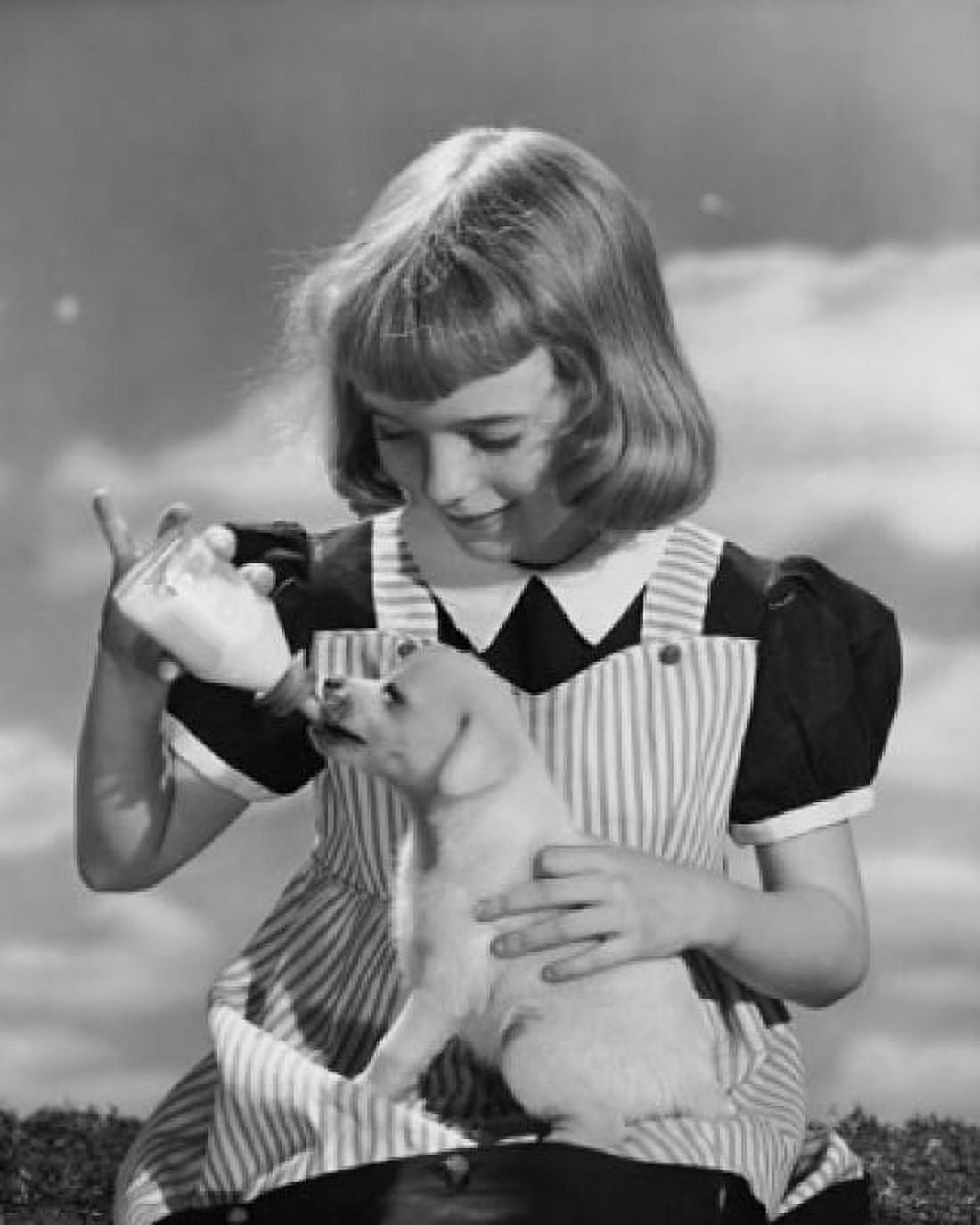 Girl feeding milk to a puppy from a baby bottle Canvas Art - (18 x 24)