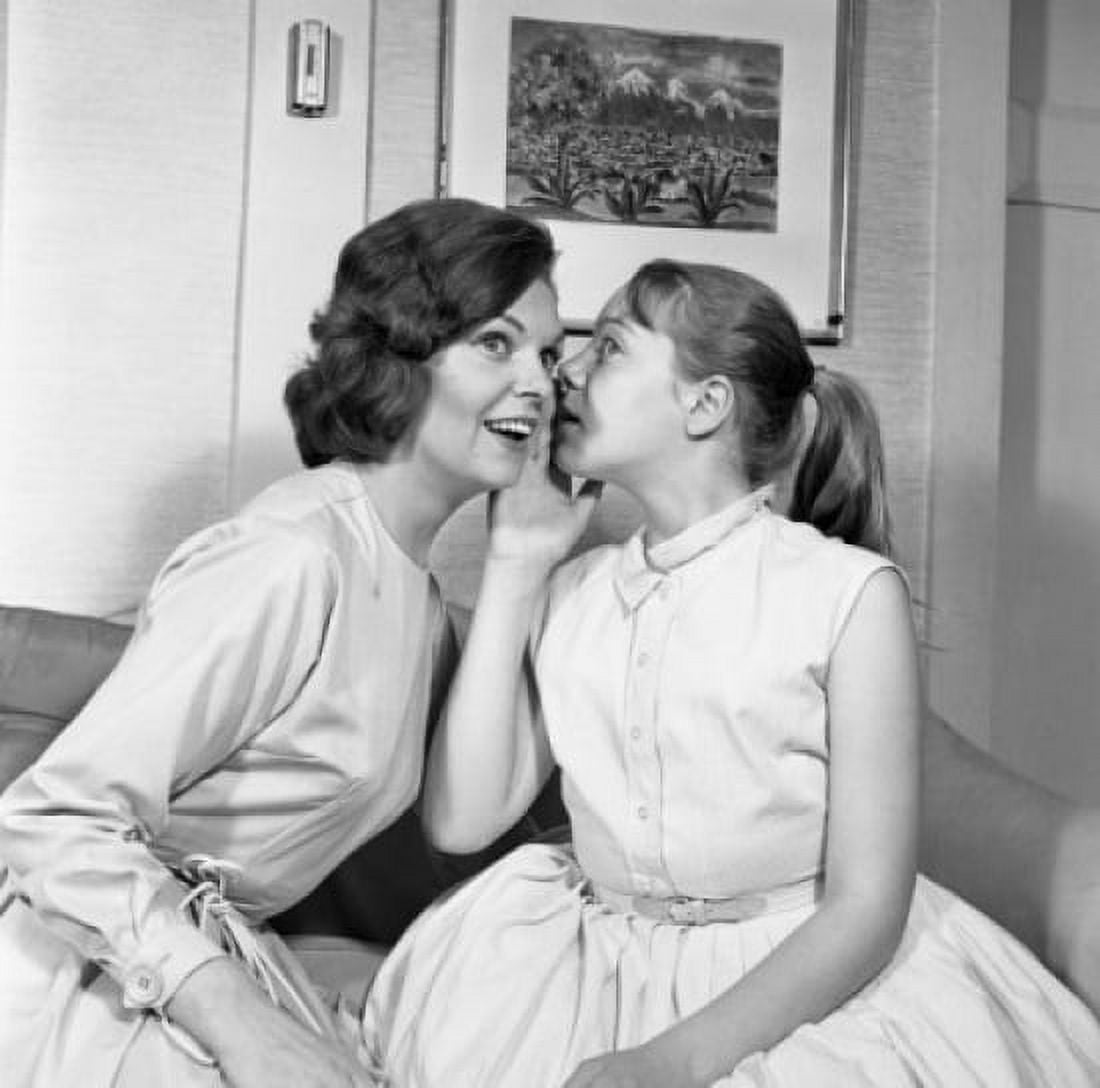 Girl hissing in young womans ear Canvas Art - (24 x 36)