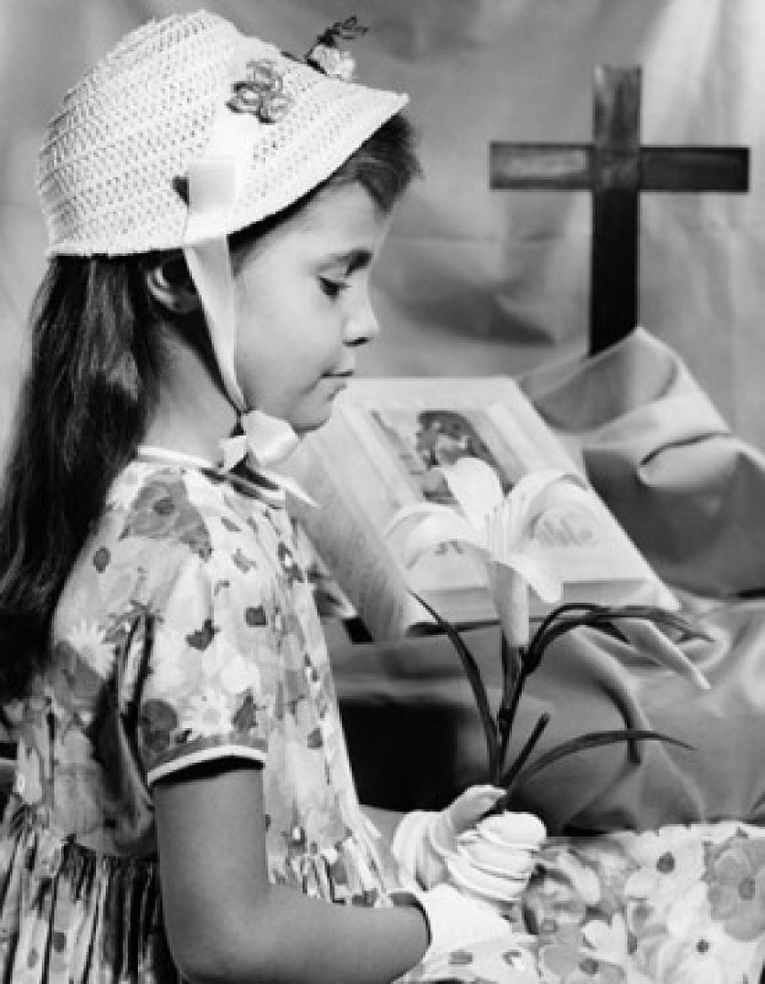 Girl holding an Easter Lily near a Bible Canvas Art - (18 x 24)