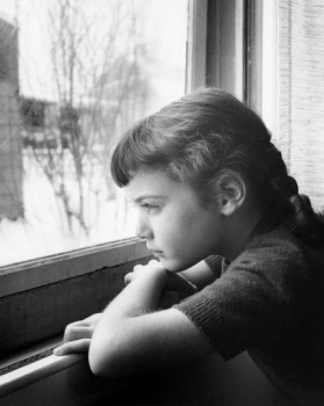 Girl leaning on sill looking out window Canvas Art - (18 x 24)