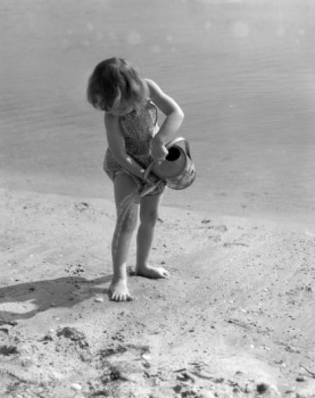 Girl playing on beach with watering can Canvas Art - (24 x 36)