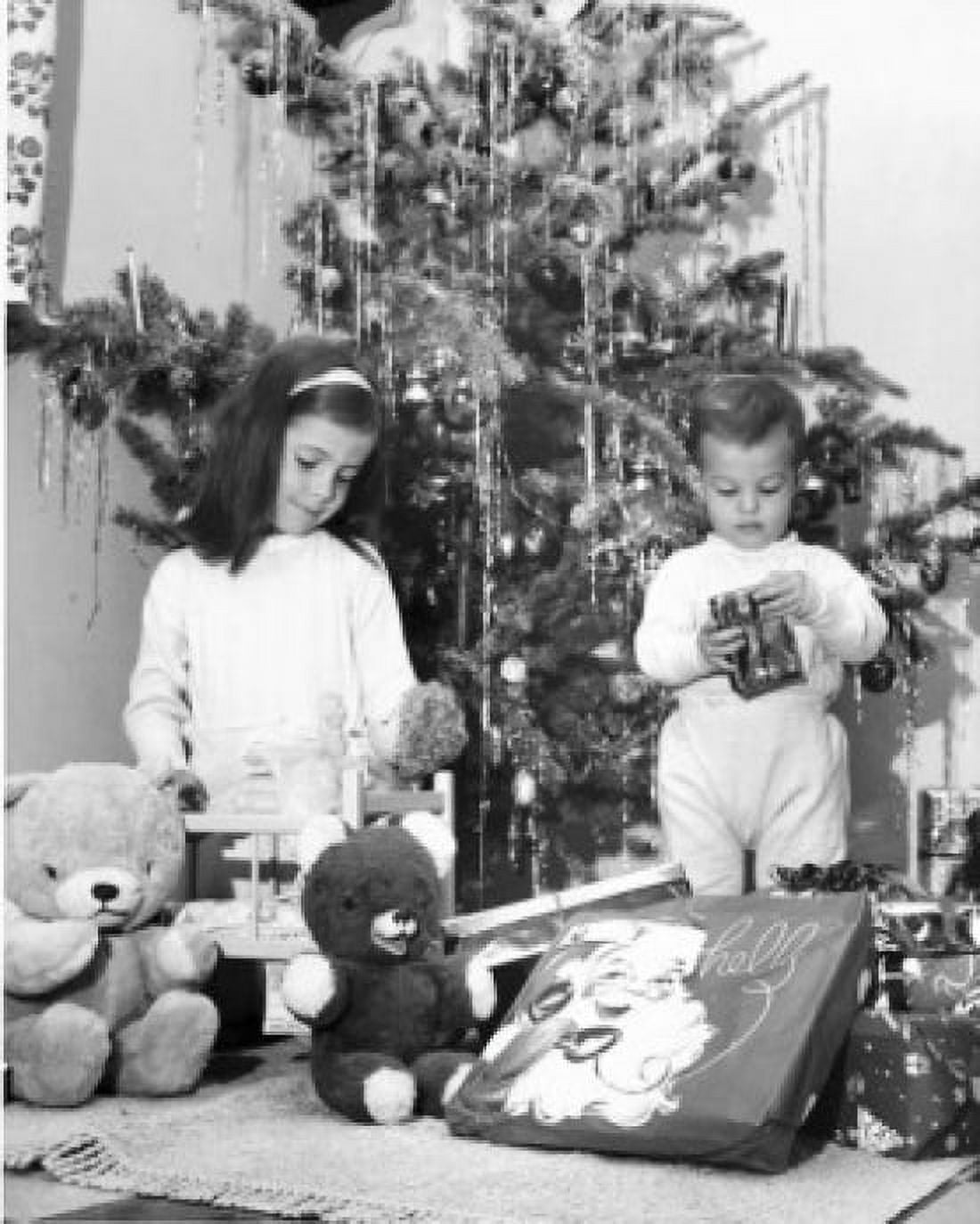 Girl playing with a doll and her brother opening a Christmas present beside her Canvas Art - (18 x 24)