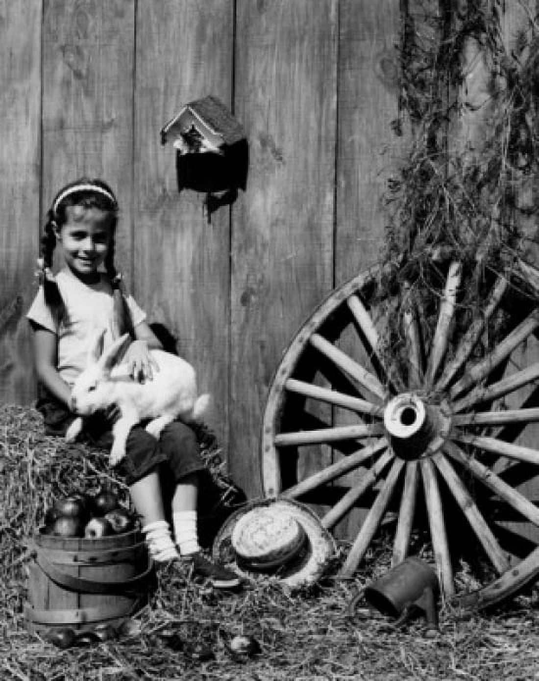 Girl playing with rabbit in rural garden Canvas Art - (18 x 24)