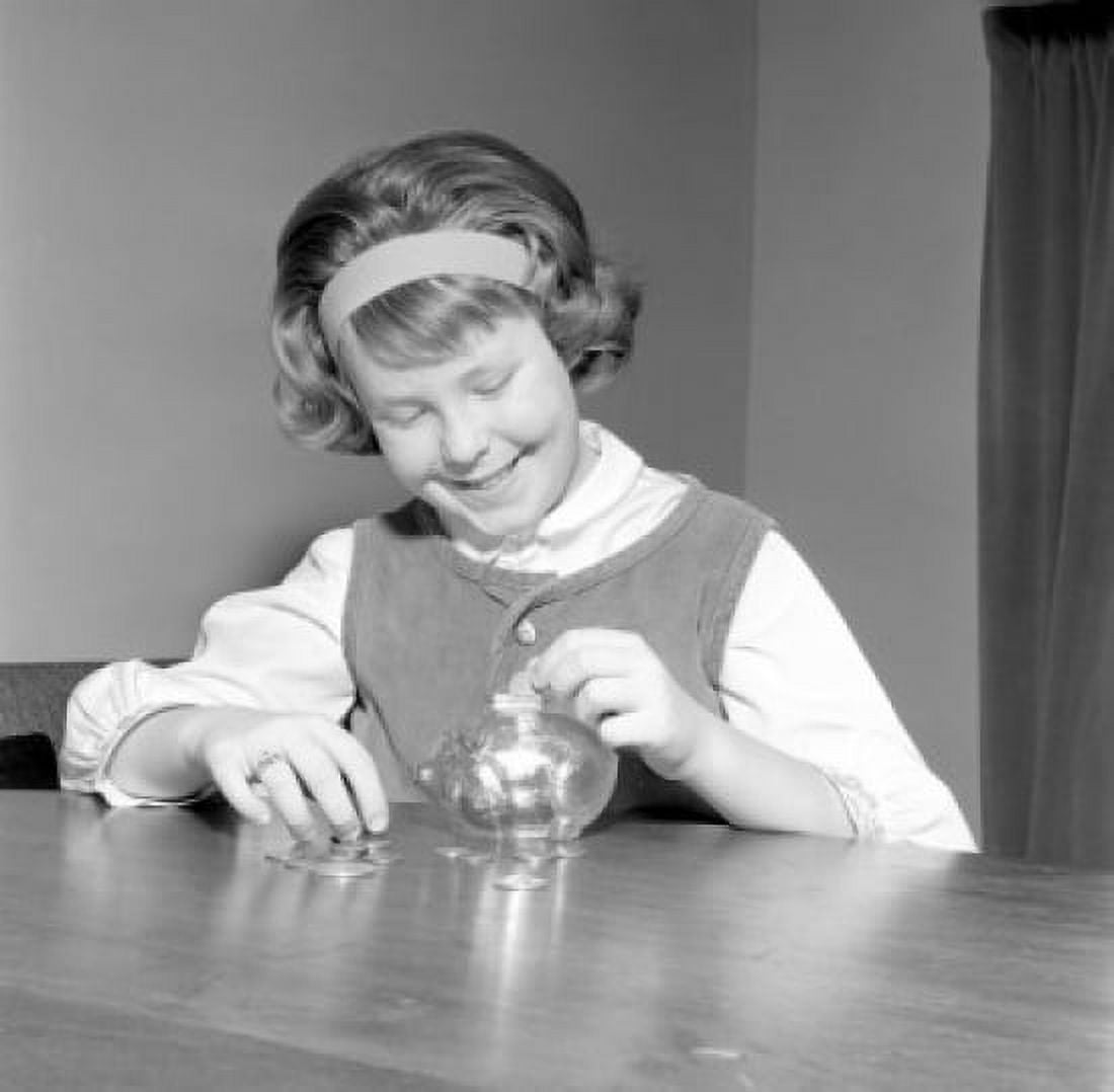 Girl putting savings in piggy bank at table Canvas Art - (18 x 24)