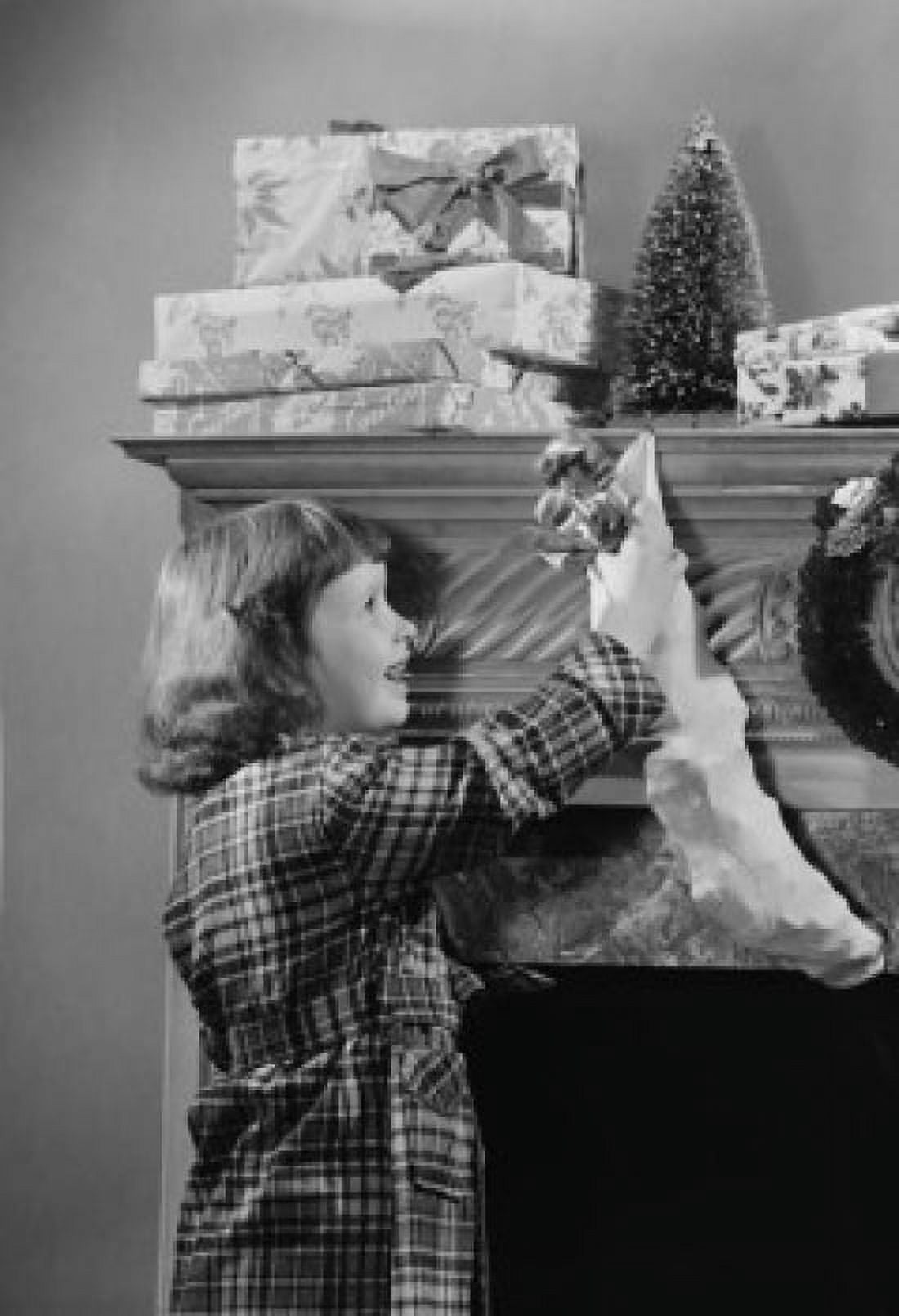 Girl reaching for Christmas presents on mantelpiece Canvas Art - (18 x 24)