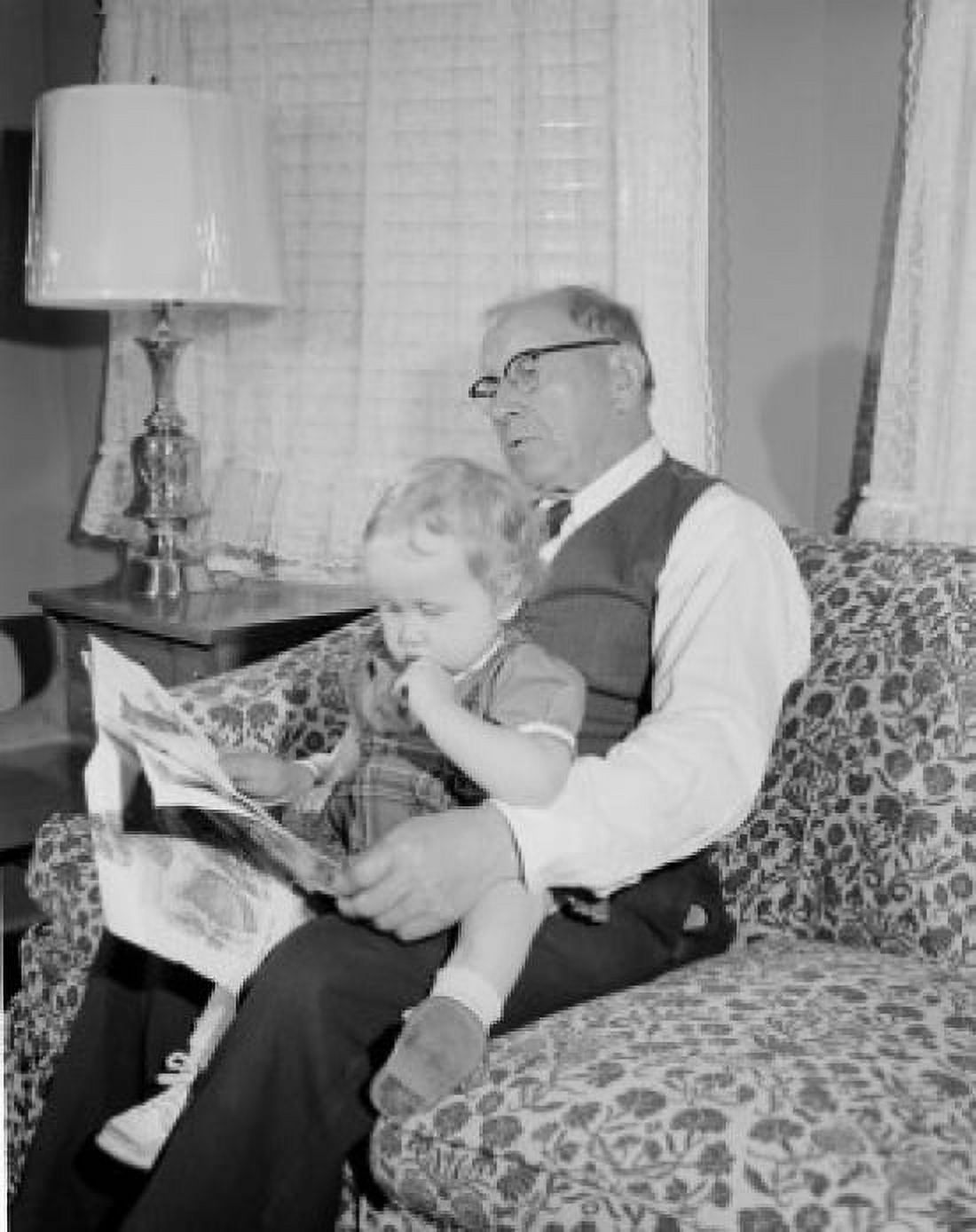 Girl reading newspaper with grandfather in living room Canvas Art - (18 x 24)
