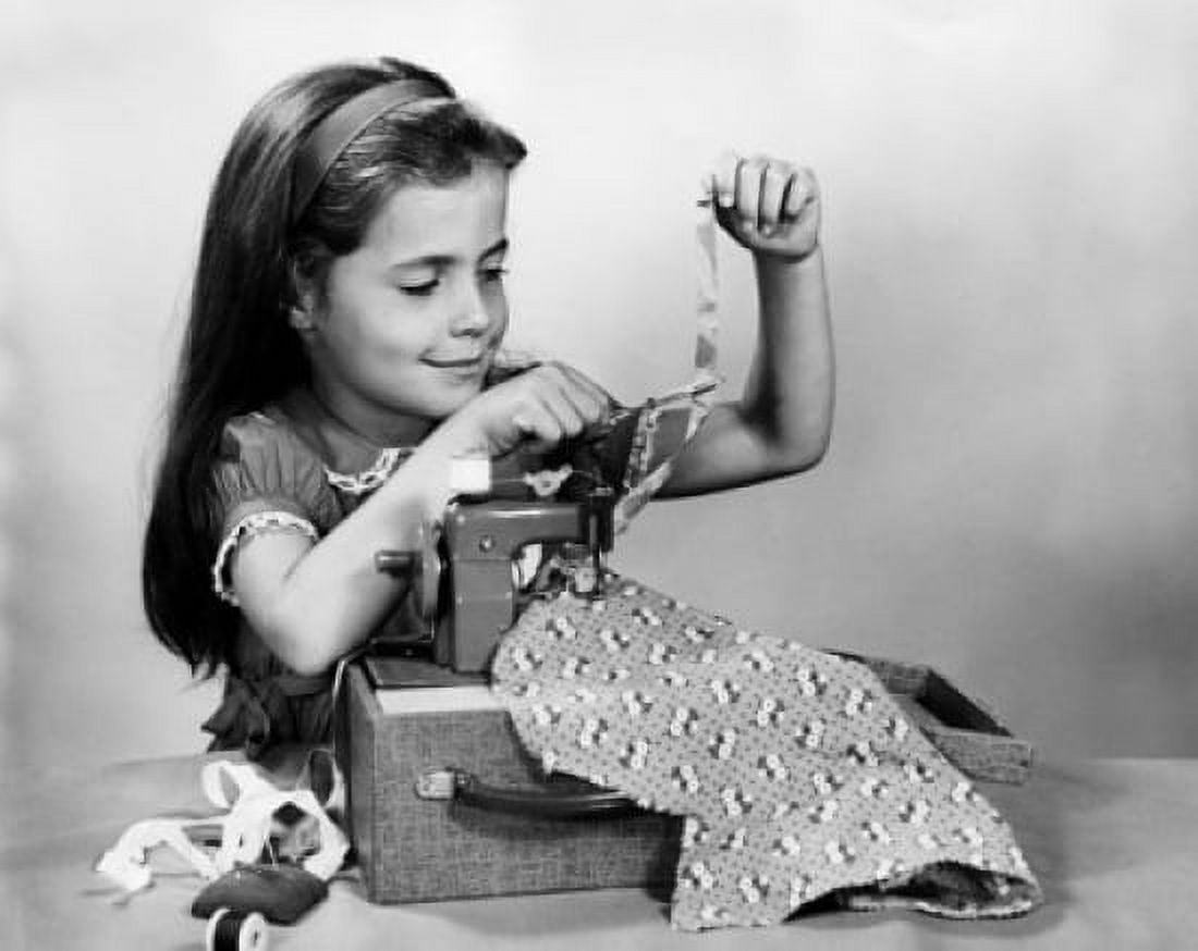 Girl sewing clothes with a toy sewing machine Canvas Art - (24 x 36)