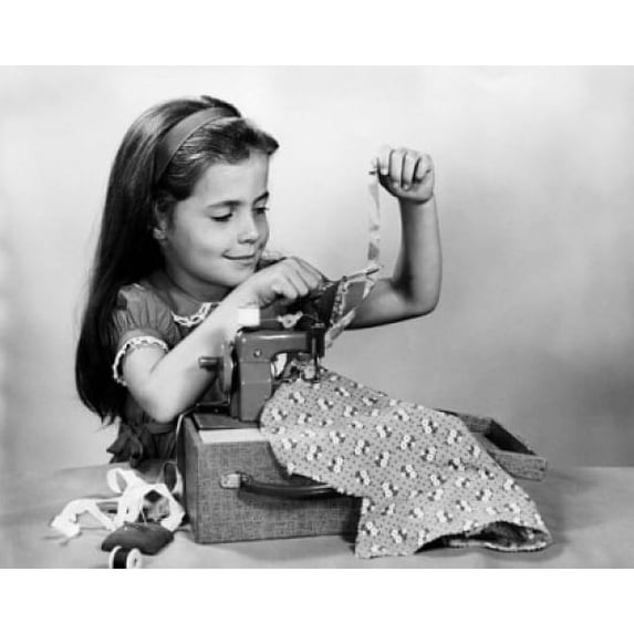 Girl sewing clothes with a toy sewing machine Poster Print (24 x 36)