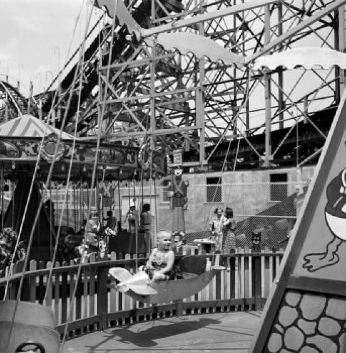 Girl sitting in merry-go-round Canvas Art - (24 x 36)