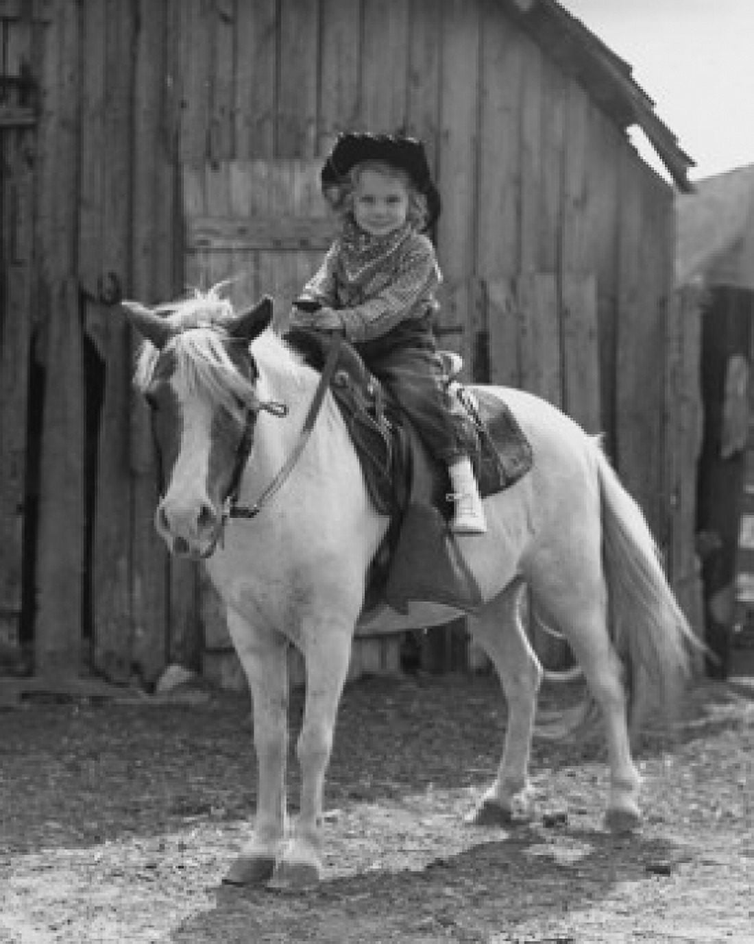 Girl sitting on a horse in front of a barn Canvas Art - (24 x 36)