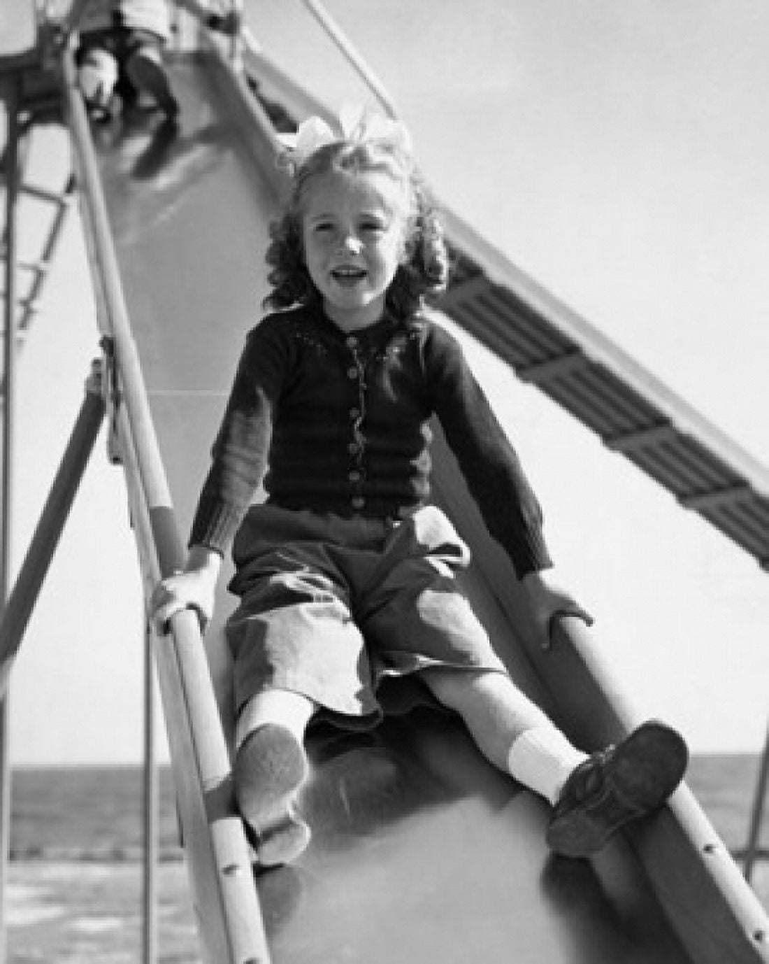 Girl sliding on a slide Canvas Art - (24 x 36)