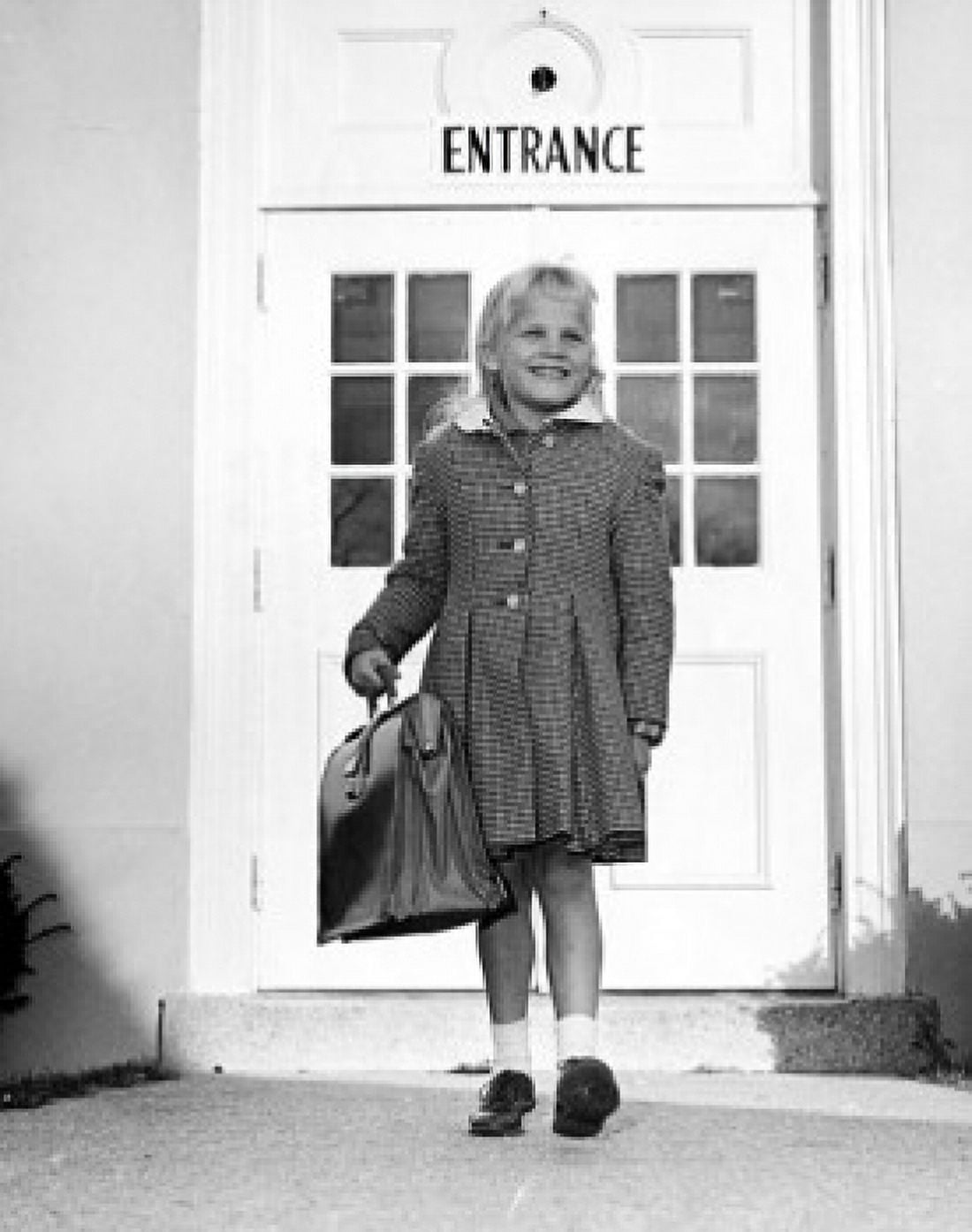 Girl standing in front of the entrance of a school and smiling Canvas Art - (18 x 24)